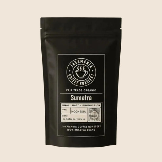 Javamainia Black coffee bag labeled Fair Trade Organic Sumatra on a soft beige background, 